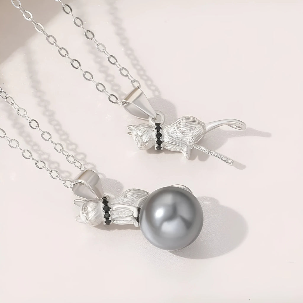 Close-up of a sterling silver cat pendant on a delicate clavicle chain necklace.