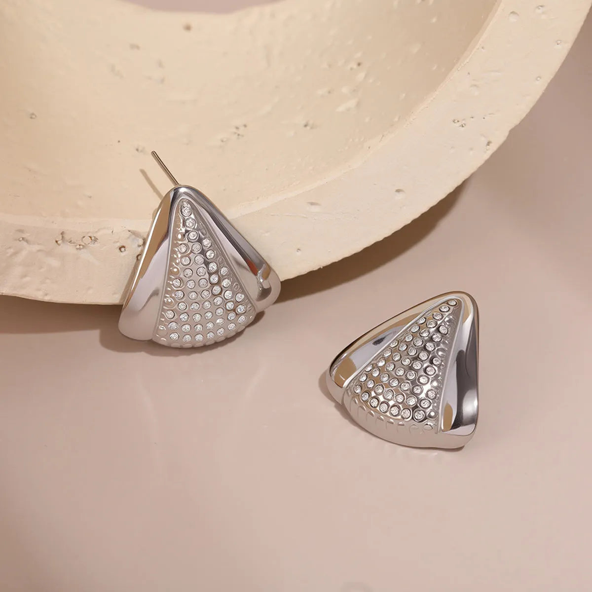 Gold triangle stainless steel geometric stud earrings with electroplated finish on white background