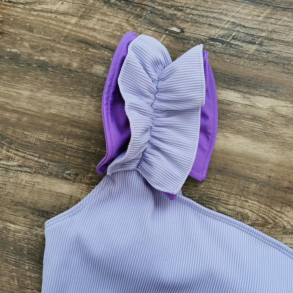Women's single-shoulder suspender tube top one-piece swimsuit in a solid colour on a mannequin.