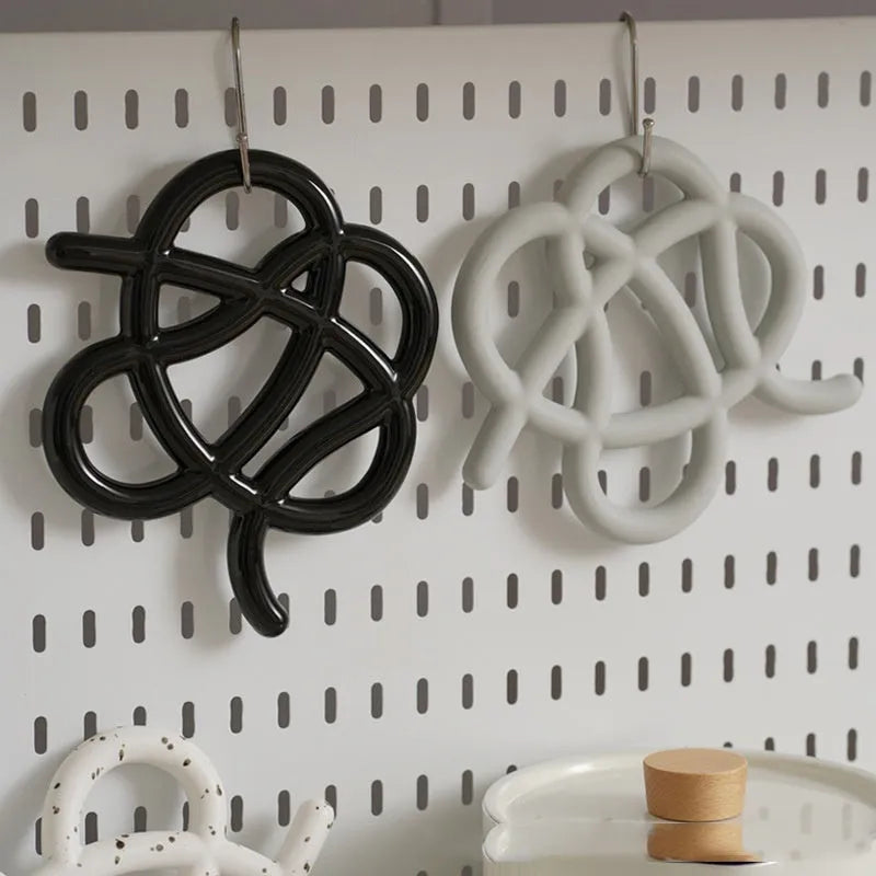 Ceramic heat proof mat with irregular shape in bright black colour on dining table