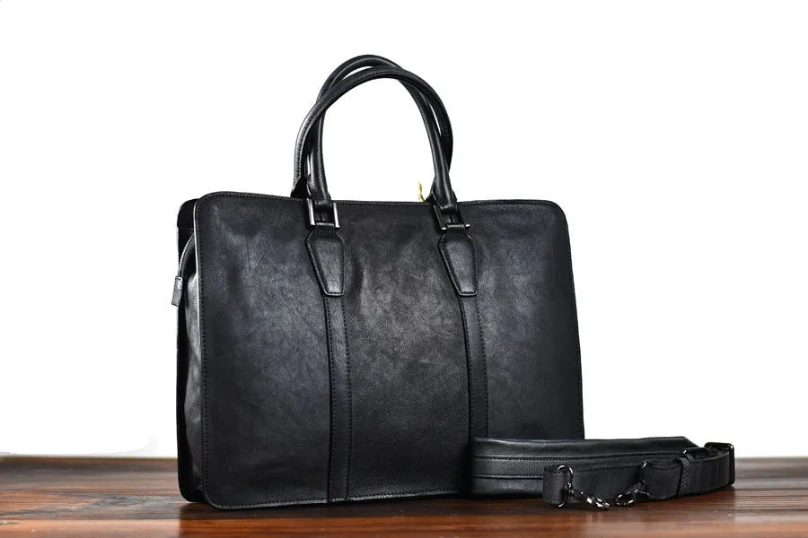 Men's brown leather retro handbag with horizontal square shape and zipper opening.