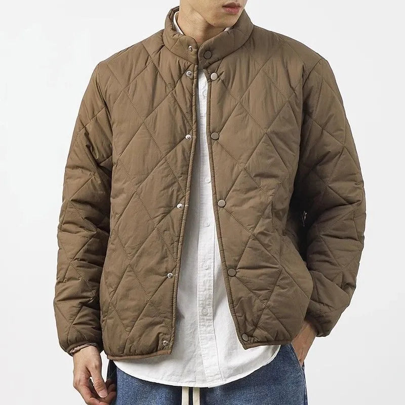 Men's black elongated winter jacket with diamond quilted pattern on a mannequin.
