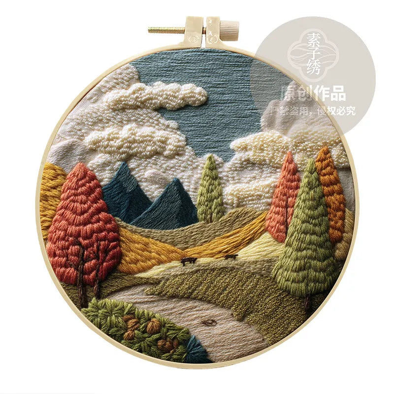 Embroidery DIY landscape kit with cotton fabric, bamboo frame, threads, and needles for handmade cloth art.