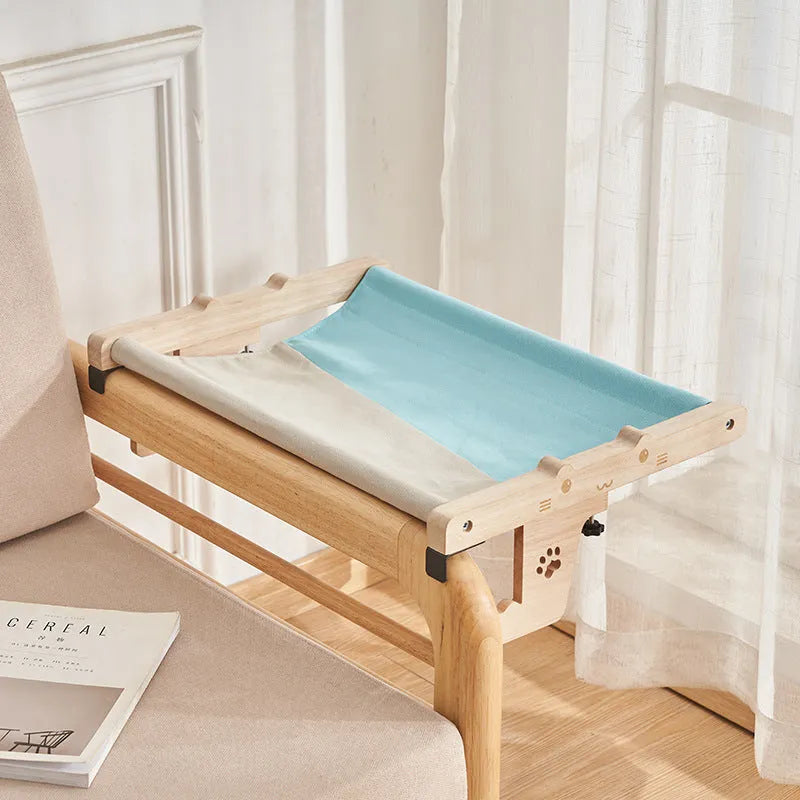 Wooden cat hanging bed hammock in a style style, mounted on a balcony railing for a cat to rest on.