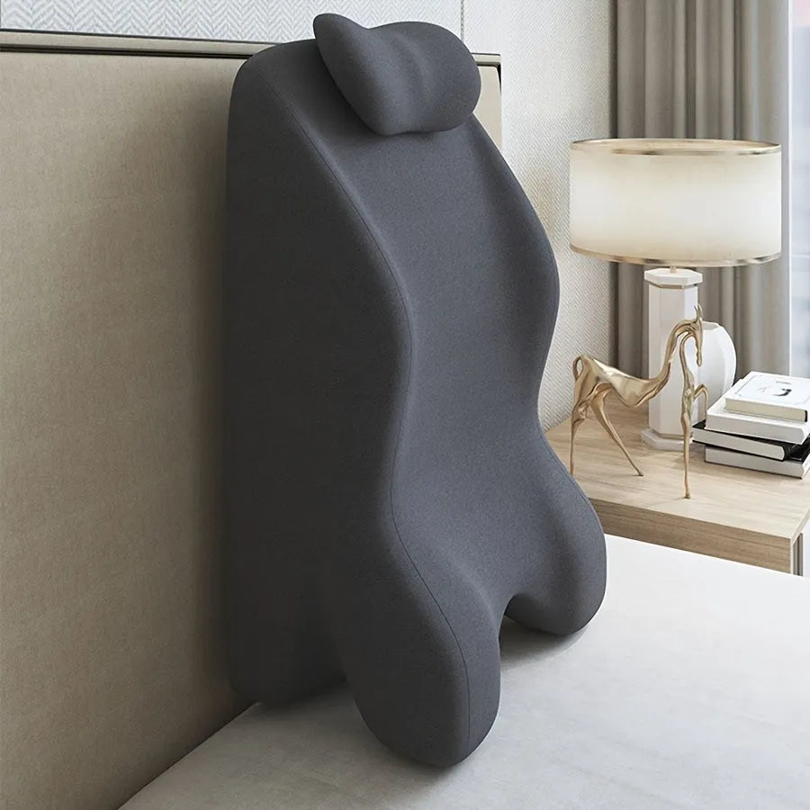 A stomach sleeper pillow in blue, designed for prone positioning and reading in bed.