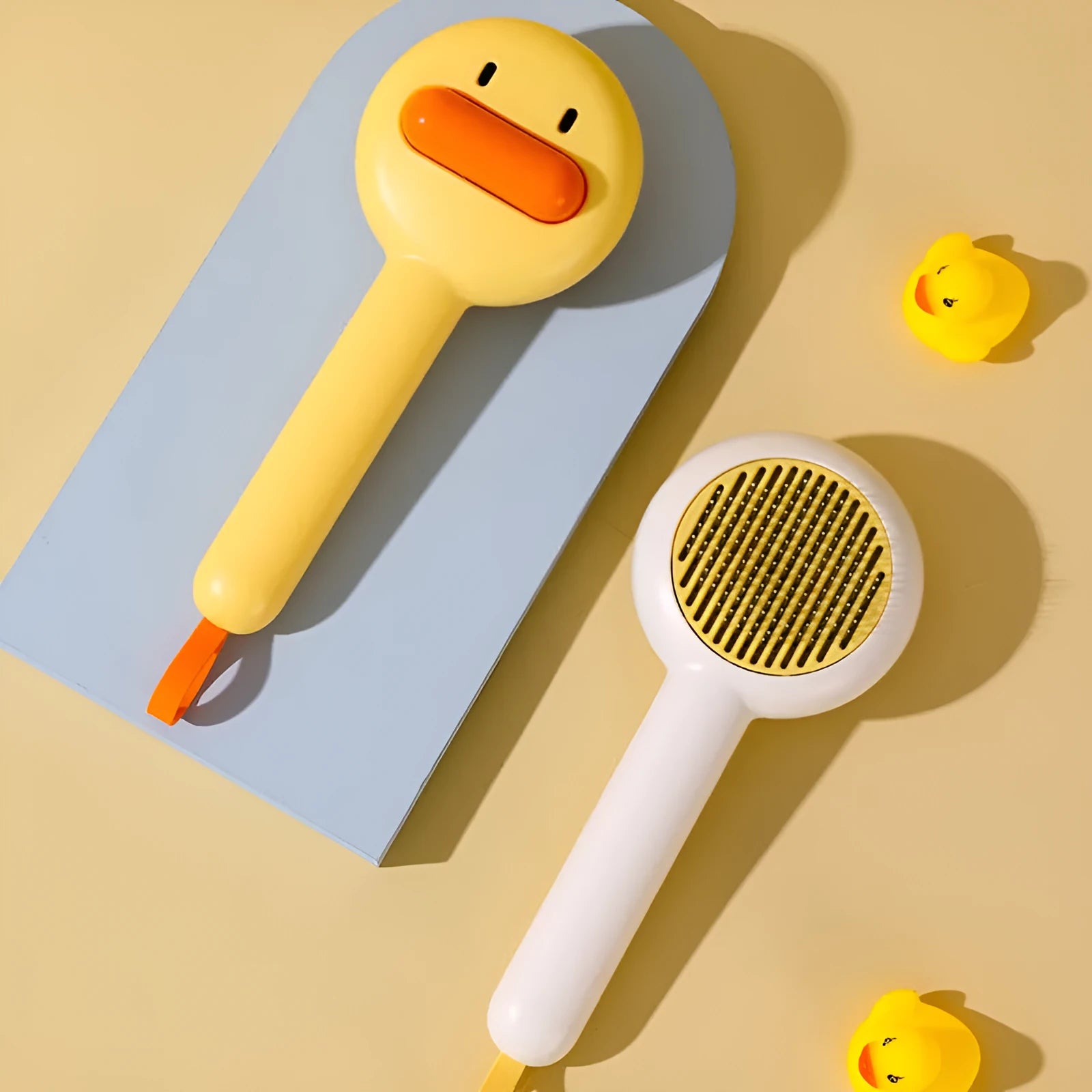 Small yellow duck-shaped pet grooming comb with needle head for hair removal on cats and dogs.