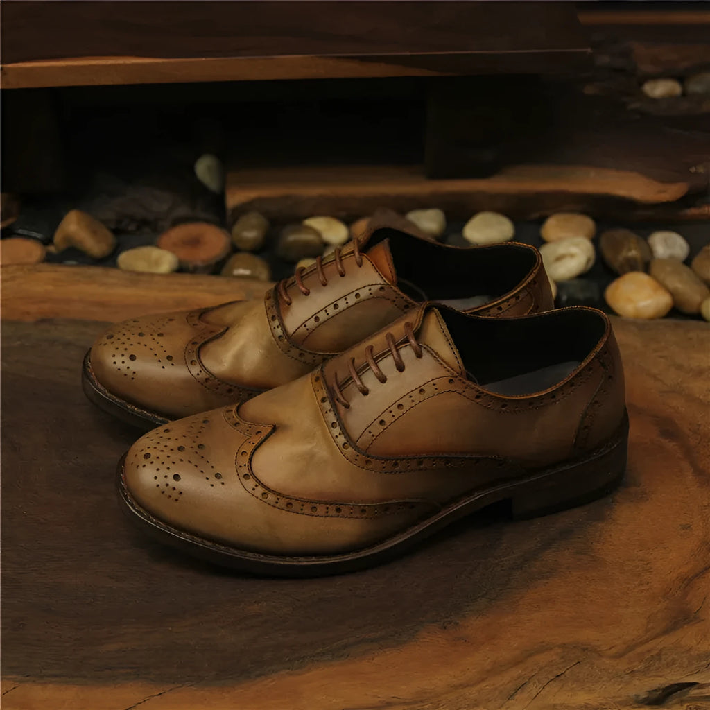 Men's light brown vintage leather lace-up shoes with carved detailing and a round toe.