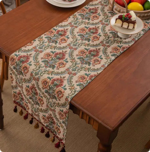 Long decorative table runner with tassels on a wooden dining table in a blue ginkgo leaf pattern.