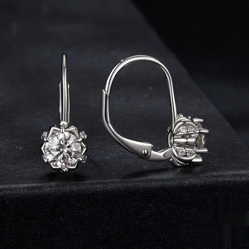 Close-up of a sterling silver floral bud ear clip with a moissanite stone and white gold plating.
