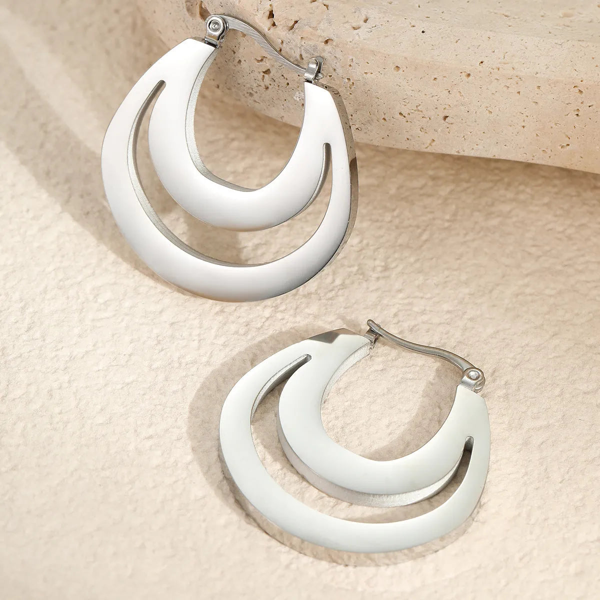 Geometric French earrings with 18K gold plating on stainless steel, featuring round ring elements in minimalist design