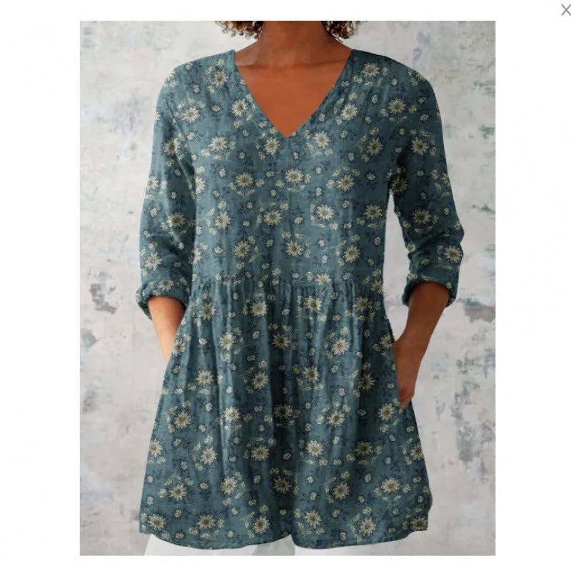 A woman wearing a vibrant printed loose-fitting dress with a wide waist and 3/4 length sleeves.