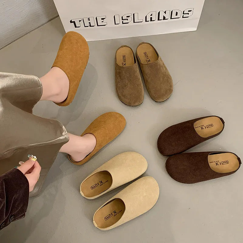 Flat apricot coloured slip-on slippers with a square toe and microfiber upper on a light surface.