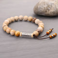 Handmade wood-colour stone bracelet with retro design on a wrist.