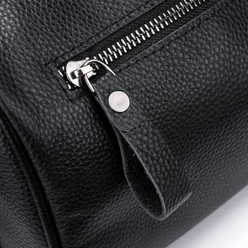 Black genuine leather crossbody bag showing front view with single shoulder strap