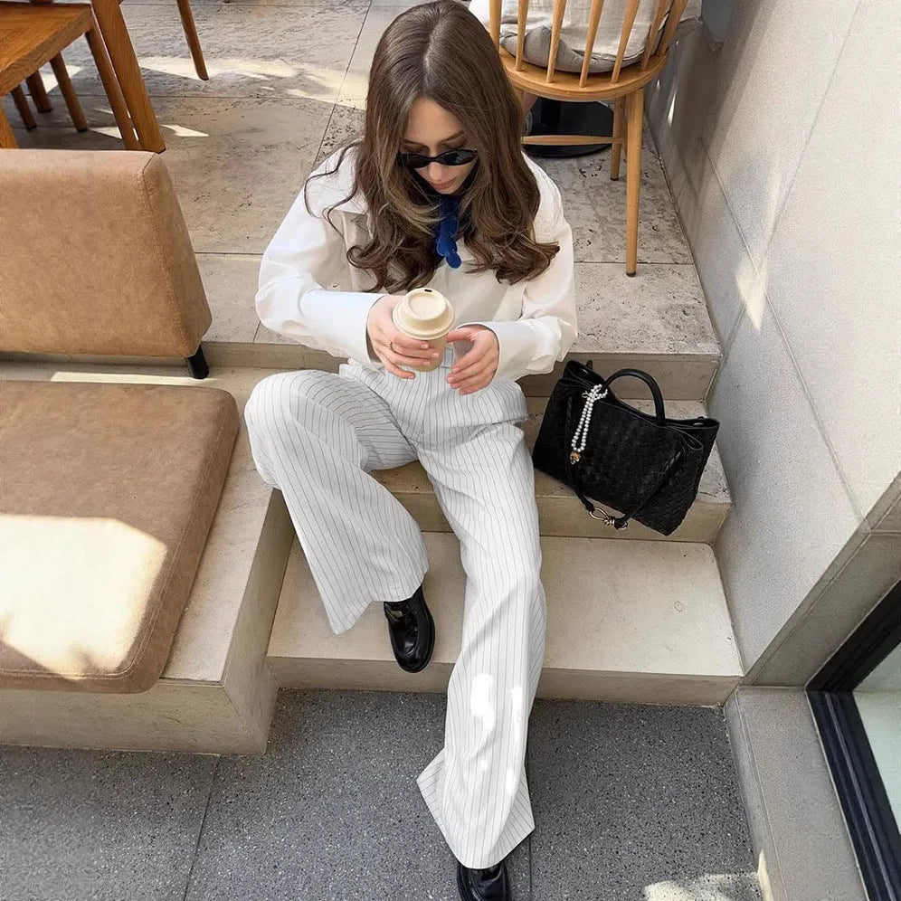 White striped wide-leg trousers with a zip fastening, laid flat.