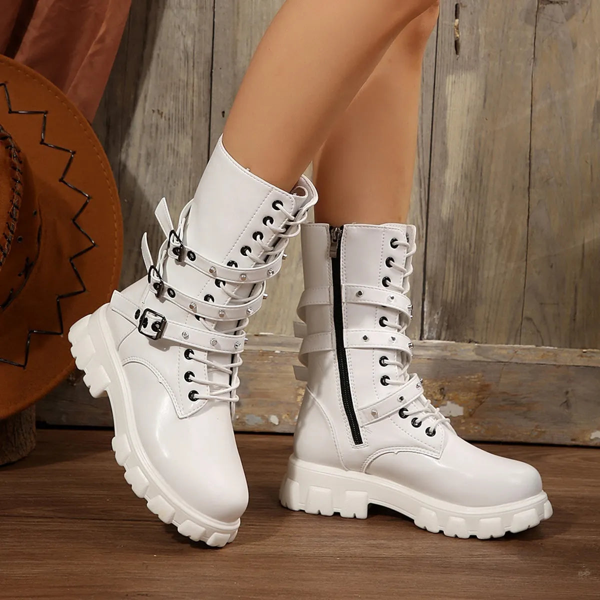 Black mid-calf women's boots with a prominent buckle detail and side zipper on a white background.