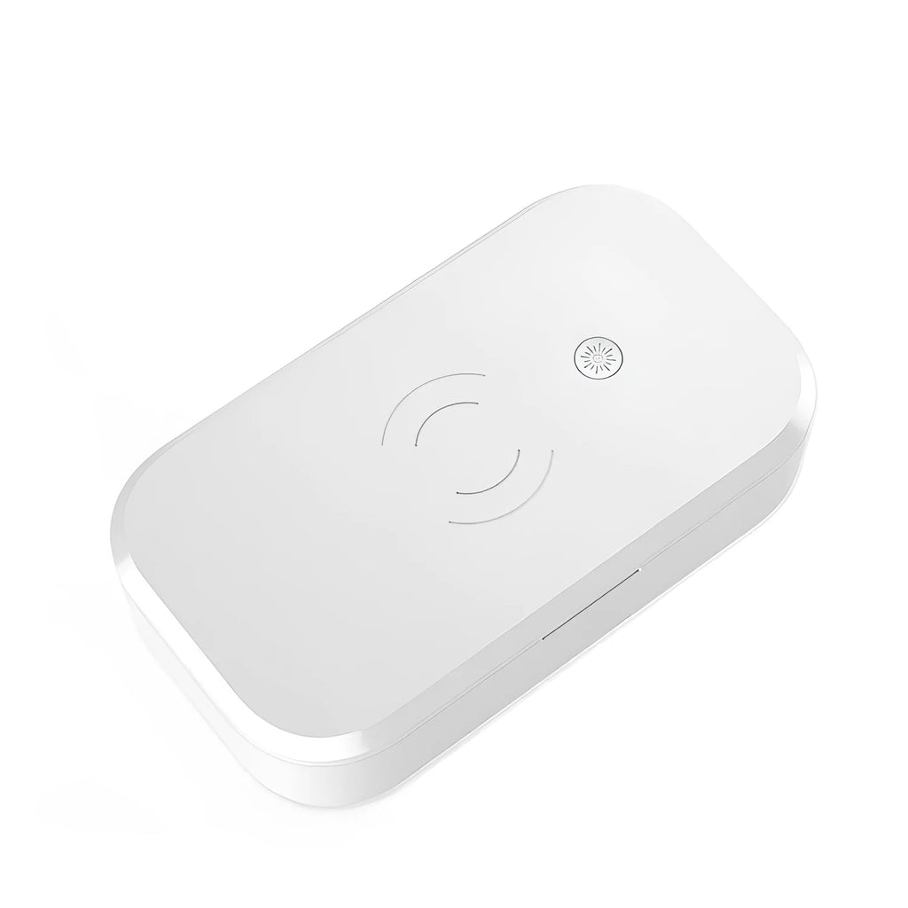 White ultraviolet disinfection box with wireless phone charger on top, shown with nail tools inside.