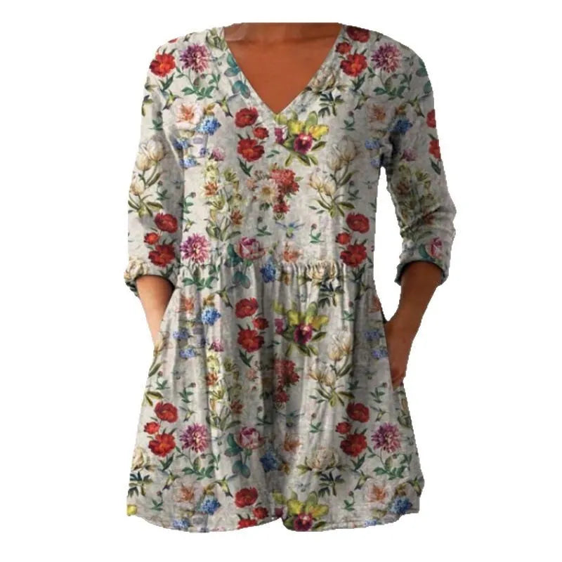 A woman wearing a vibrant printed loose-fitting dress with a wide waist and 3/4 length sleeves.