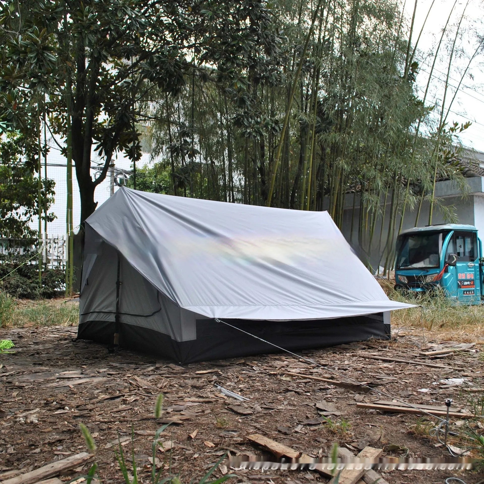 Brown A-frame hiking tent supported by hiking poles showing spacious interior for 2-3 campers