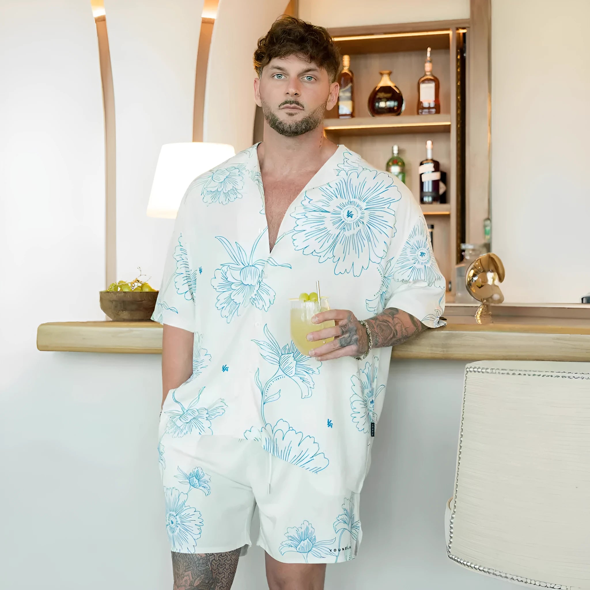 Man wearing a loose, light grey printed short sleeve casual top made from stretch polyester fabric.