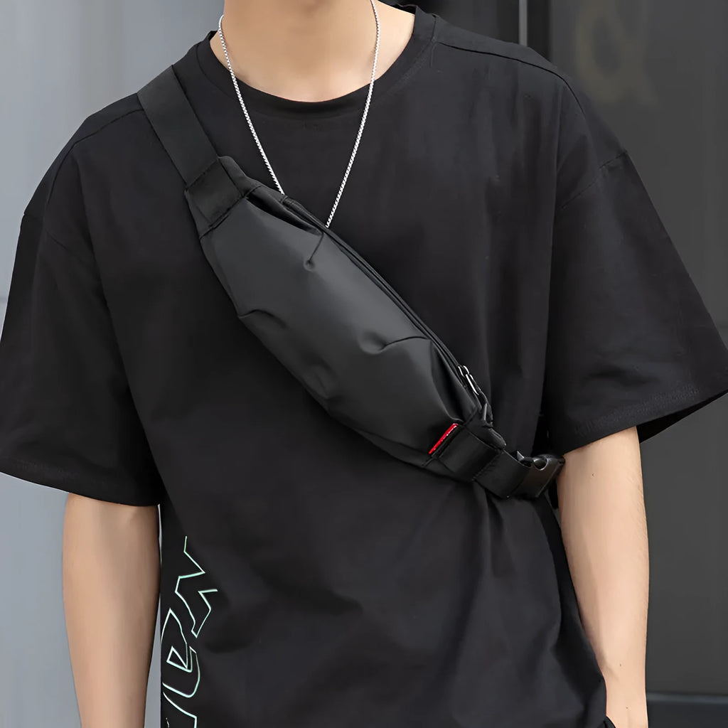 Black Oxford cloth waist pack showing front zipper and compact rectangular shape.