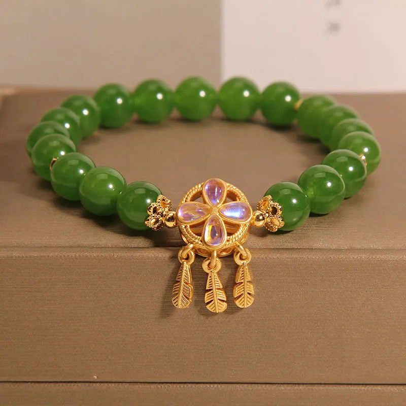 Women's green jasper crystal bracelet with four-leaf clover and dream catcher pendant, original design, on white background