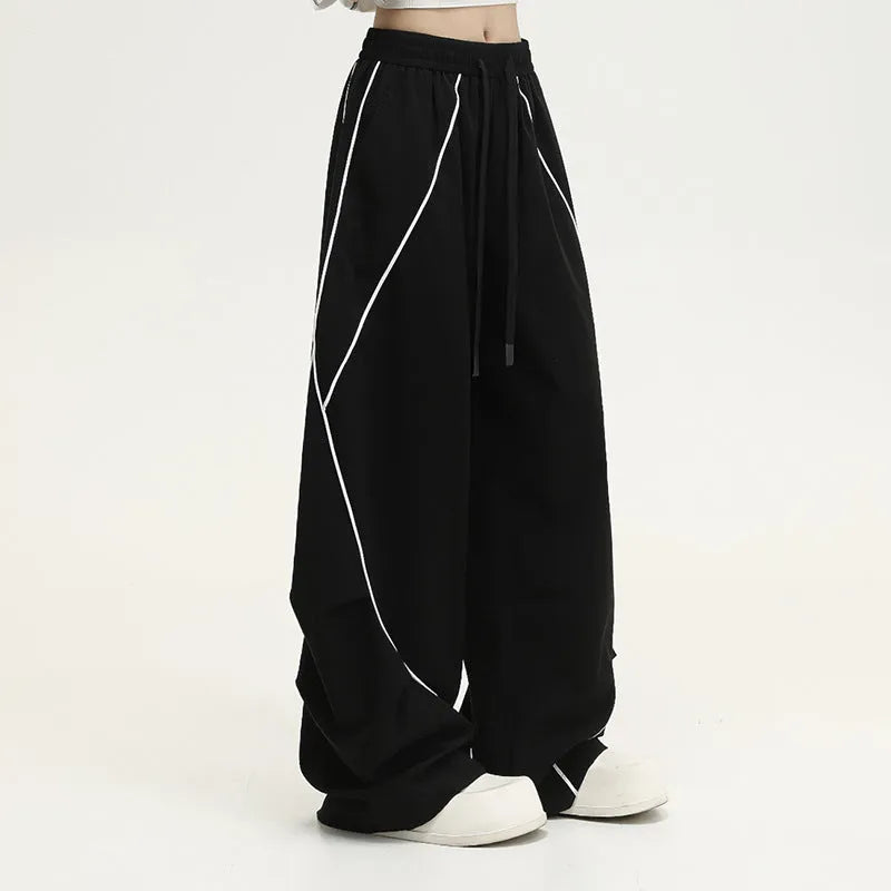 Black pleated wide-leg trousers with striped pattern showing mid-waist design and loose fit