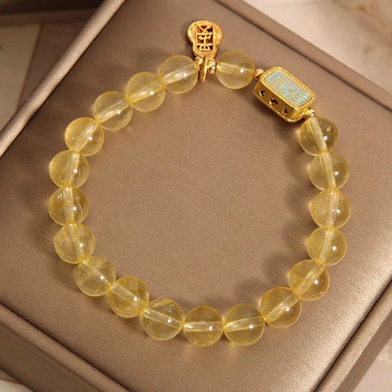 Natural citrine yellow crystal bracelet for women with rhinestone accents on a white background
