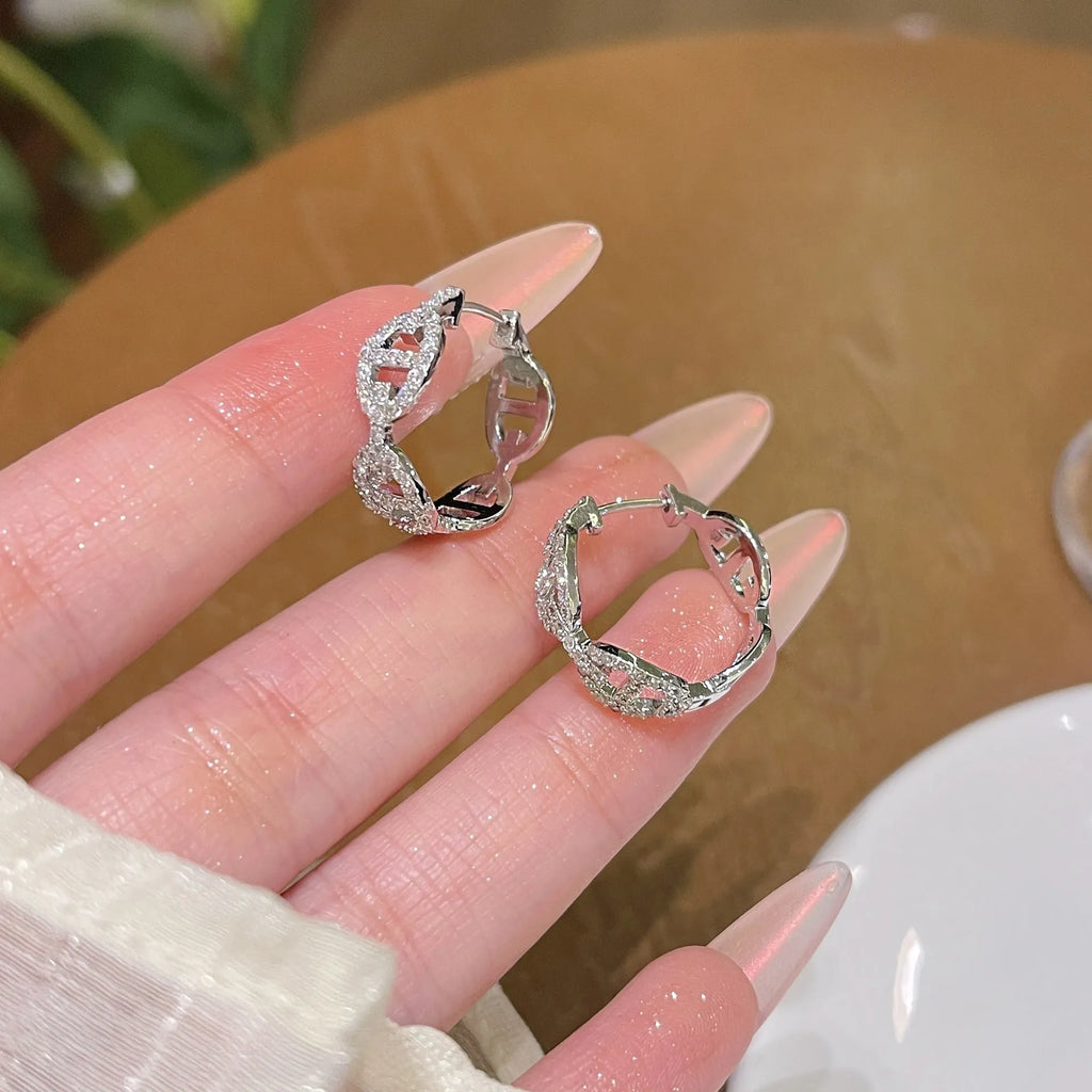 A pair of women's diamond-look fashion earrings with thick gold plating, shown in silver, gold, and rose gold colour options.