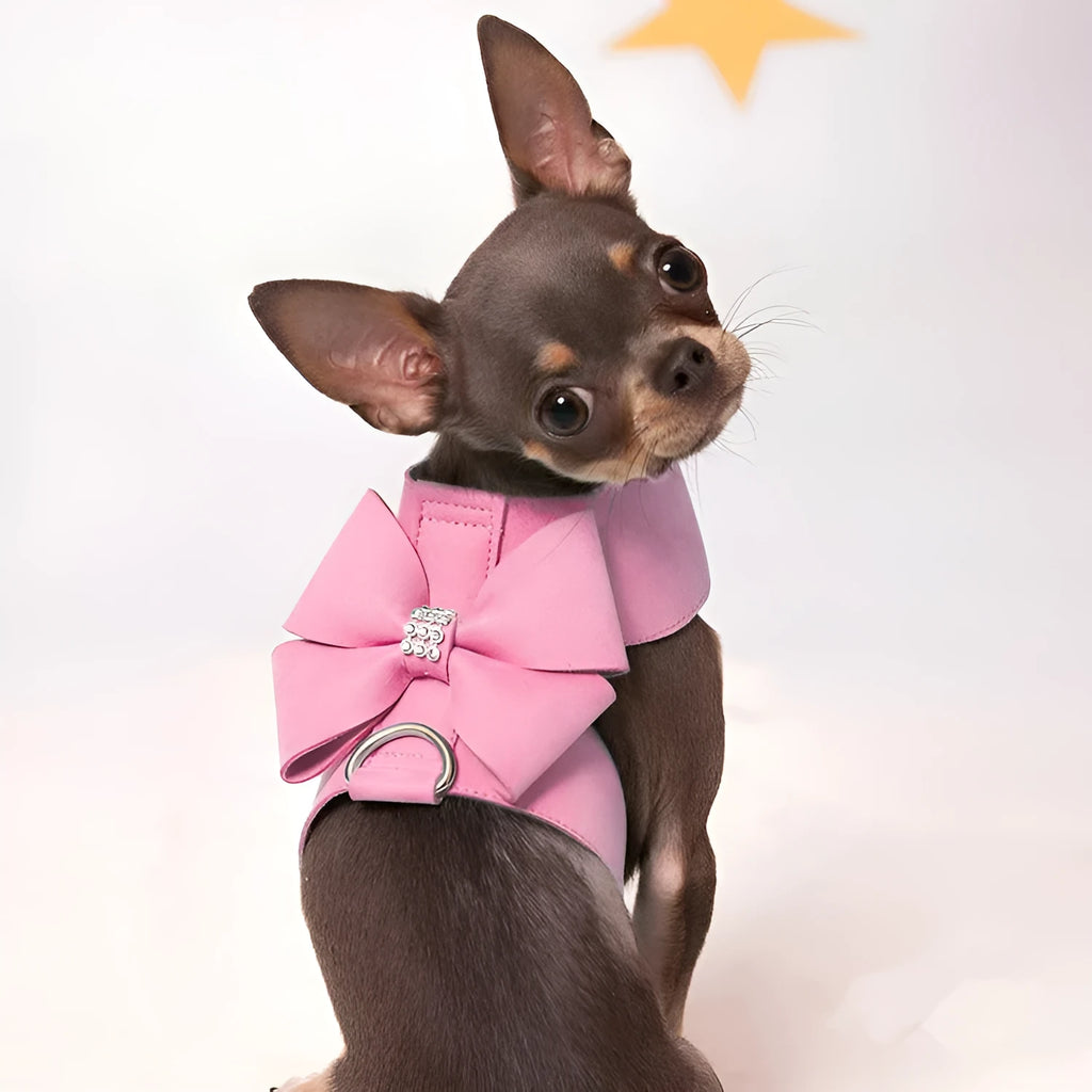 Pink microfiber dog chest strap with a large white bowknot, showing adjustment buckle and D-ring.