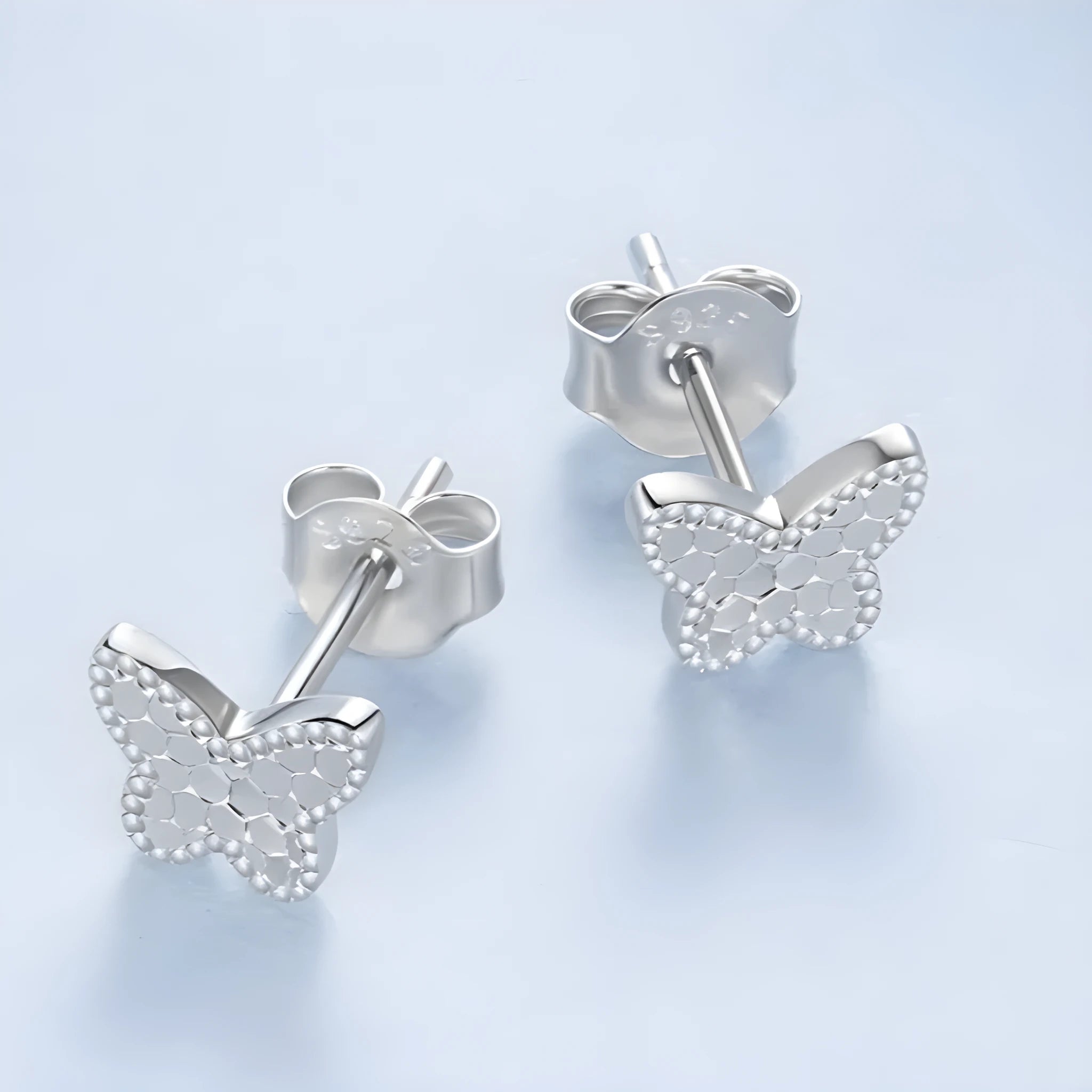 Pair of original S925 sterling silver butterfly stud earrings with shiny electroplated finish on white background