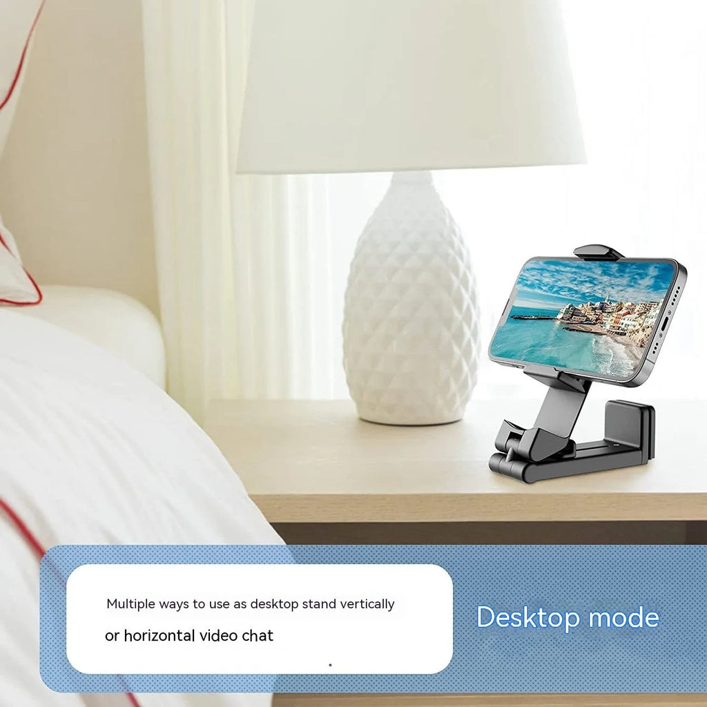 Foldable rotating universal phone holder in black, green, and grey colours on a desk.