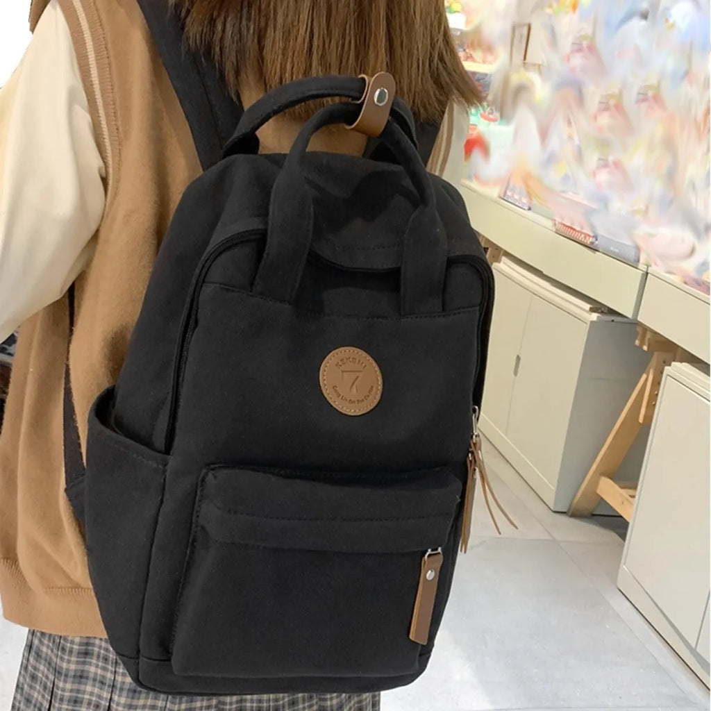 Black fashion backpack made of Oxford cloth with curved shoulder strap and retro stitching for school and travel