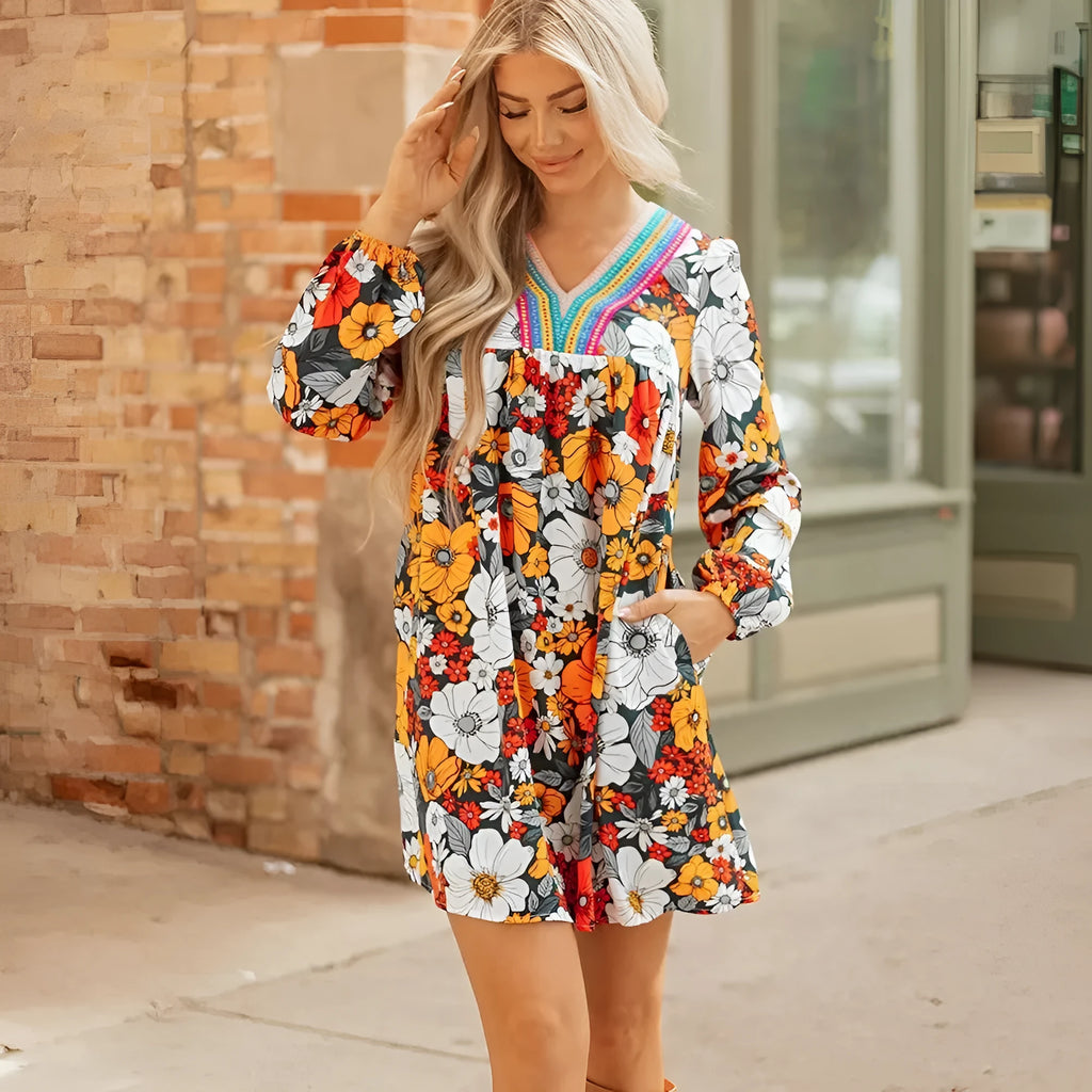 Orange floral and striped patterned mini dress with a lace-trimmed V-neck collar and long sleeves.