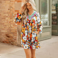 Orange floral and striped patterned mini dress with a lace-trimmed V-neck collar and long sleeves.