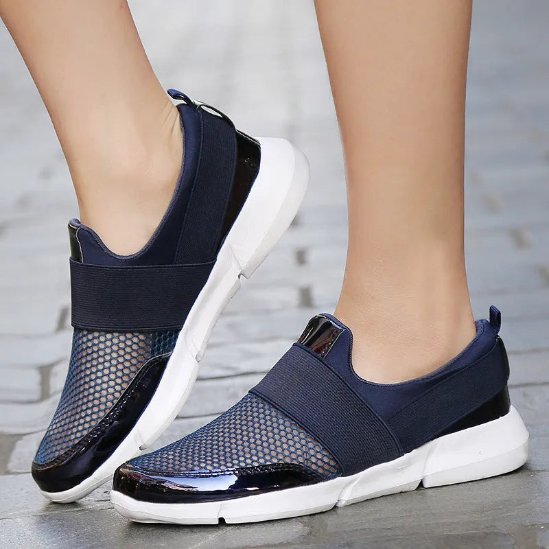 Women's blue breathable sneakers with mesh interior and low-top design on indoor surface