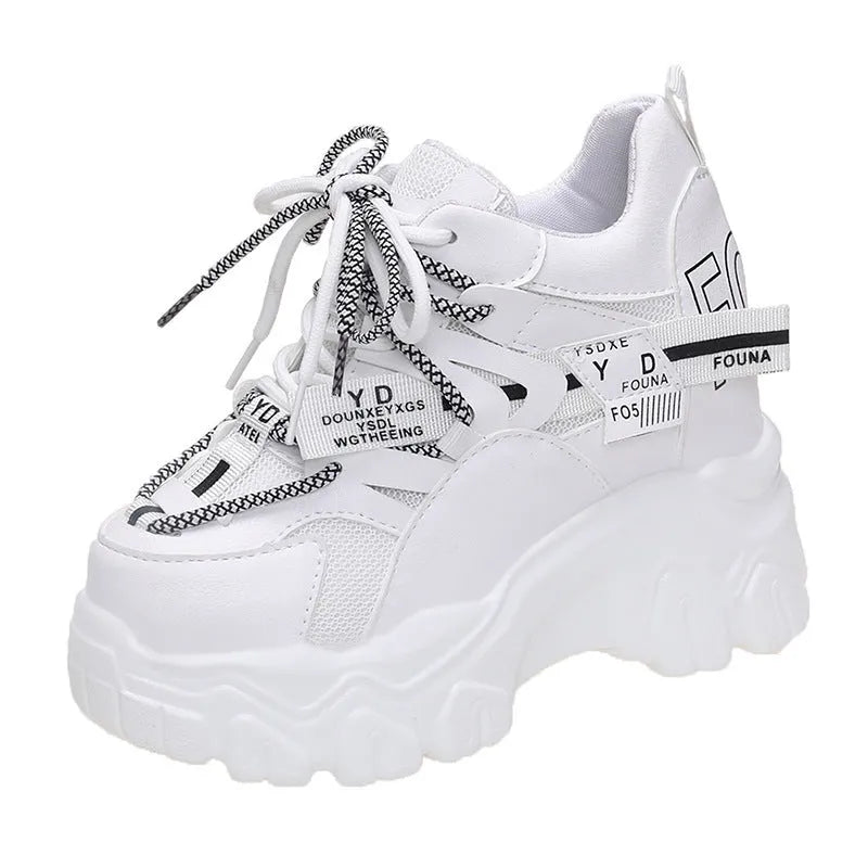 White and black women's low-top platform sports shoes with cross-strap and mesh design on a rubber sole.