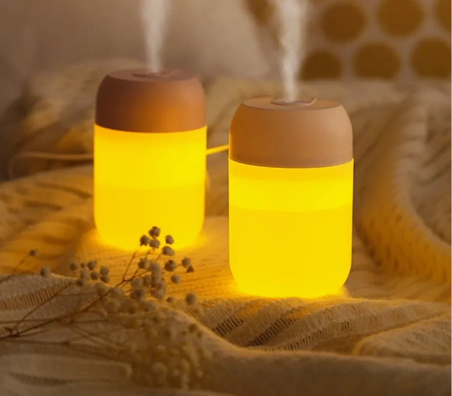 White cylindrical USB-powered mini humidifier on a desktop.