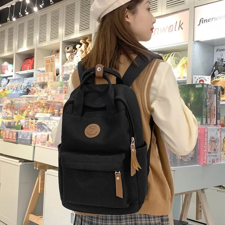 Black fashion backpack made of Oxford cloth with curved shoulder strap and retro stitching for school and travel
