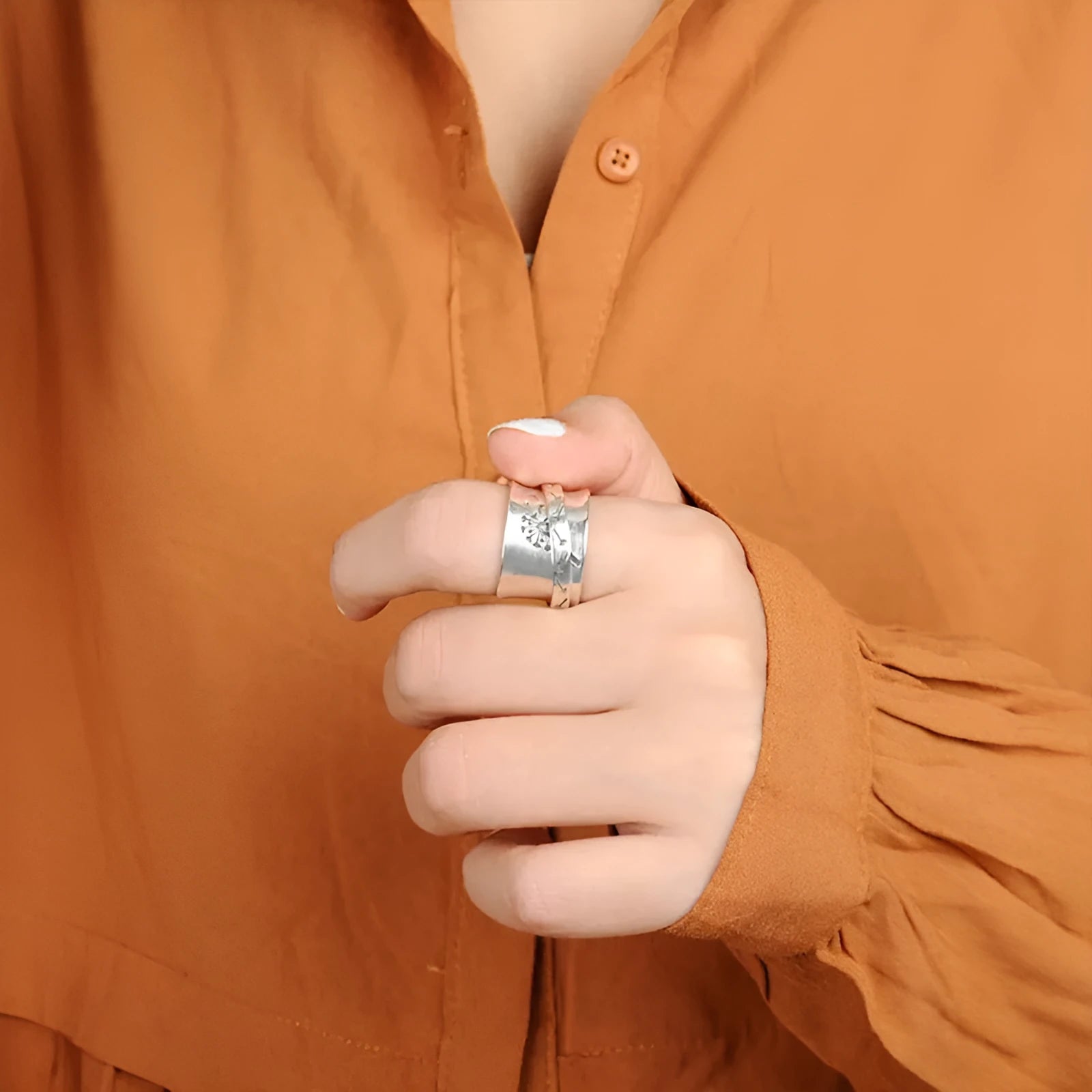 Silver rotating flower ring showing floral element and band details