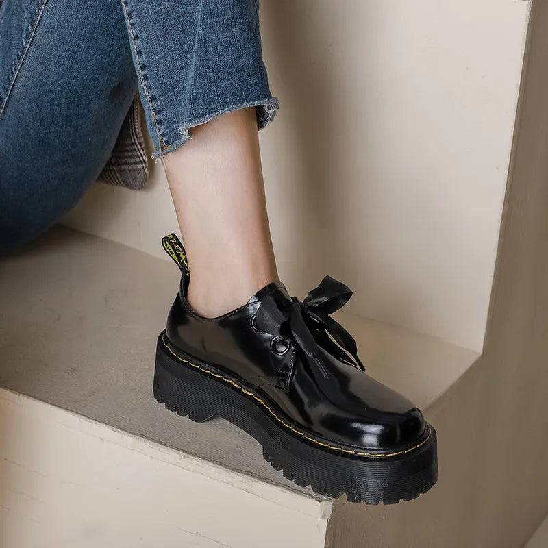 Women's thick-soled leather shoes with ribbon and cross strap details in lace-up design