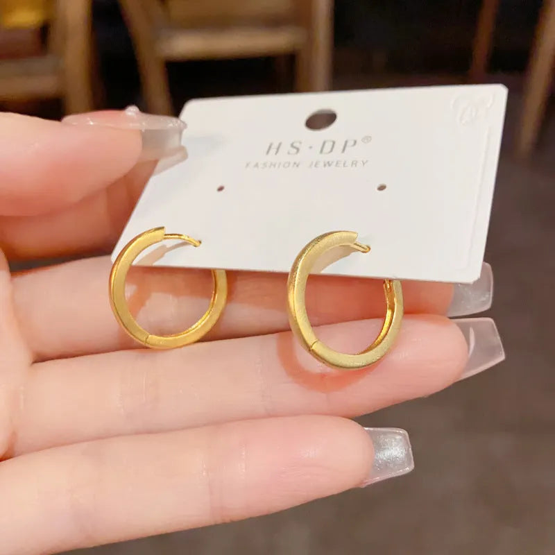 Geometric circle ear clips with gold plating and eyelet detail for women's pierced ears