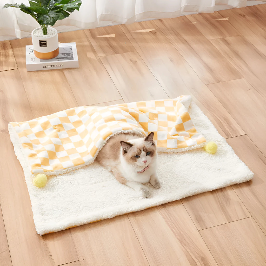 Green plaid pattern plush fleece pet blanket laid flat, showing soft texture and fur ball decoration.