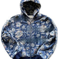 Man wearing a blue loose-fit zip-up hoodie with a hood, shown in a casual setting.