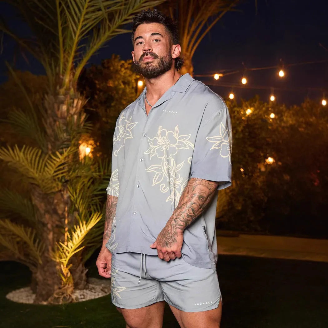 Man wearing a loose, light grey printed short sleeve casual top made from stretch polyester fabric.