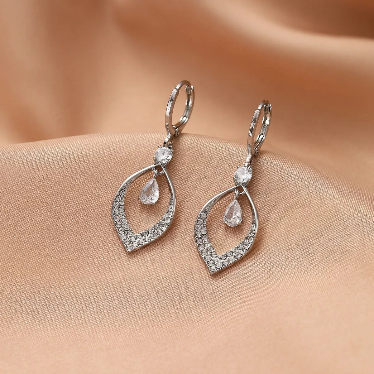 Gold and silver women's drop tassel earrings with zircon detail on a water drop shape.