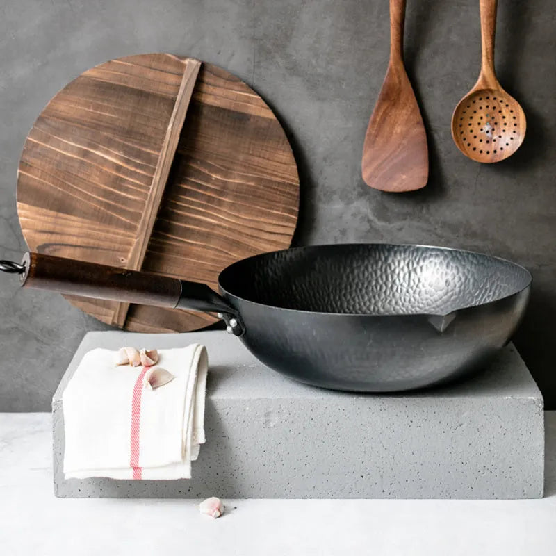 Traditional handmade iron wok pan with wooden handle and black finish