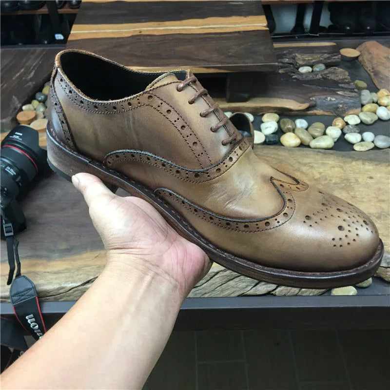 Men's light brown vintage leather lace-up shoes with carved detailing and a round toe.