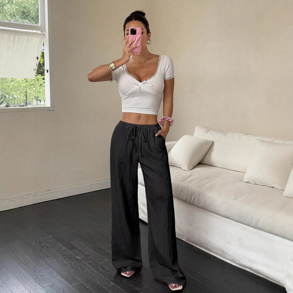 Women's black wide-leg trousers with lace-up waist detail on hanger