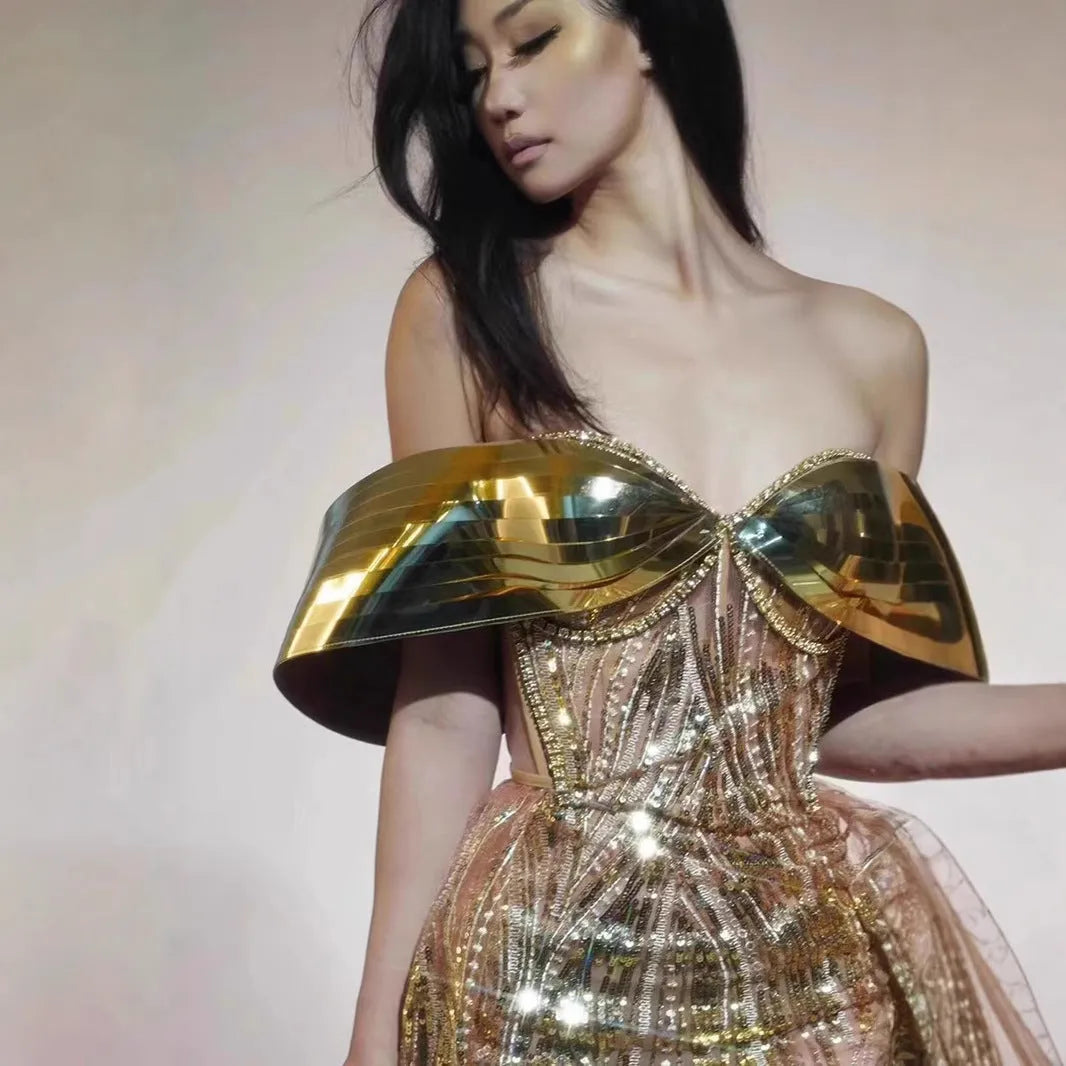 Gold sequined strapless long dress with a side split and tube top, shown on a model.